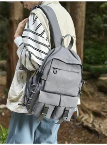 Zaino grigio di grande capacità indossato da una persona in un bosco verde