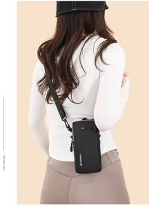 Back view detail of a slim black vertical crossbody phone bag on a model in a white top