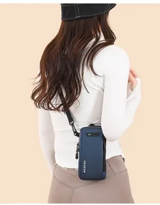 Rear view of a blue lightweight crossbody phone bag worn by a model in sports attire