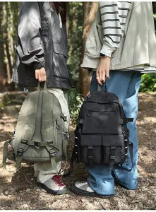 Modelli con zaini outdoor grandi oliva e nero in una scena forestale.