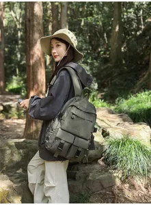 Scatto lifestyle all'aperto di un grande zaino verde militare indossato in una foresta.