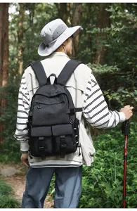 Vista posteriore di uno zaino da trekking nero di grande capacità in un bosco fitto