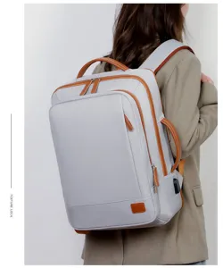 Modieuze grijze waterdichte laptoprugzak gedragen door model, grote reistas met USB-poort