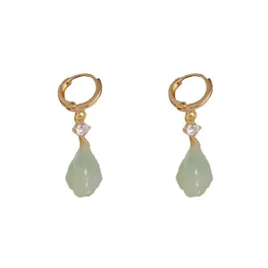 Vue détaillée des boucles d'oreilles dorées avec gouttes d'eau vert clair