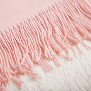 Close-up of pink soft wool-blend oversized scarf with long tassel fringe details