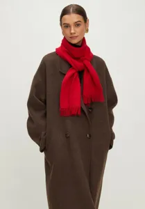 Rode gebreide sjaal met fijne kwastjes voor de winter, getoond op een modetalent.