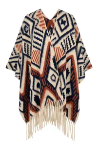 Close-up detail of Bohemian geometric pattern and tassel fringe on ethnic style poncho.