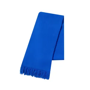 Detailopname van Klein blauwe gebreide sjaal met decoratieve kwastjes afwerking.