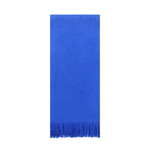 Detailopname van een levendige kleinblauwe gebreide sjaal met zachte kwastjesfranjes.