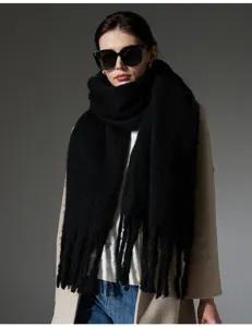 Vista detallada de una bufanda gruesa de imitación de mohair negro con flecos en una modelo