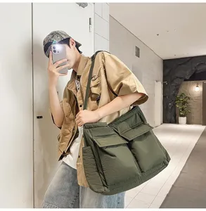 Olive green large capacity canvas messenger bag shown on model in a mirror selfie detail