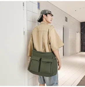 Large olive green padded canvas crossbody bag worn by a male model in a corridor