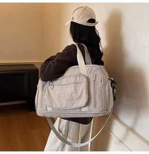 Large capacity beige travel duffel bag with shoulder strap shown in lifestyle setting