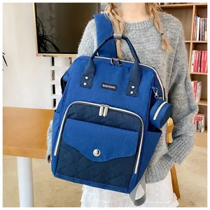 Mochila de lona azul para pañales con patrón acolchado y bolsa lateral pequeña