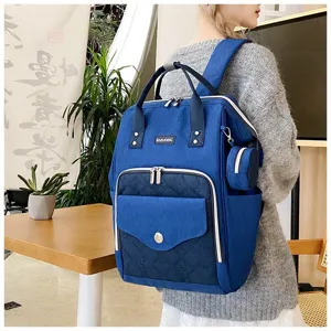 Vista detallada de la elegante mochila pañalera de lona azul con varios bolsillos funcionales