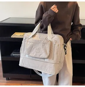 Detail view of a large capacity beige travel bag with multiple zippers and HUAYUN logo