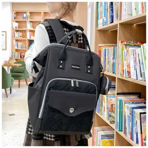 Vista detallada de la mochila pañalera de lona negra con bolsillo acolchado corazón