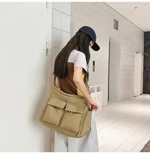Asian model wearing a stylish khaki large capacity canvas messenger bag in a modern hallway