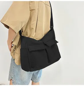 Side view of a large black canvas crossbody bag for students, durable and vintage style.