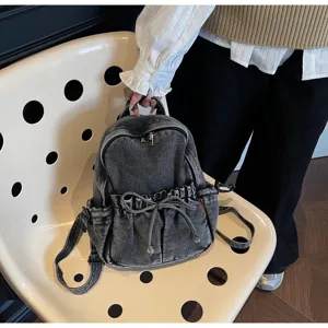 Sac à dos décontracté en denim gris pour femme avec nœud à cordon sur une chaise