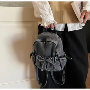 Gros plan d'un sac à dos élégant en denim anthracite pour femmes avec détail de nœud coulissant