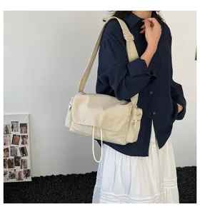 Detailansicht einer beigefarbenen Messenger-Bag aus Nylon, getragen von einem Modell.