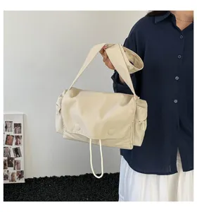 Minimalistische beige Nylon-Umhängetasche für Damen, von einem Model stilvoll gehalten.
