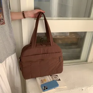Large brown quilted gym and travel tote bag in a stylish lifestyle indoor setting