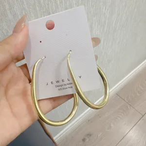 Close-up of minimalist matte gold geometric hoop earrings with 925 silver posts