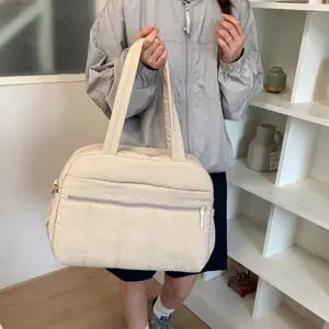 Large capacity beige quilted travel tote bag for women shown in a lifestyle setting
