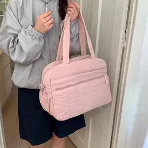 Large capacity pink quilted cloud bag for gym and short travel carried by model