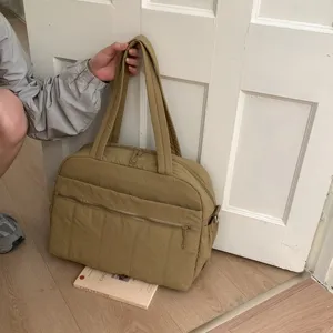 Large khaki quilted travel tote bag for women shown in a minimalist indoor setting
