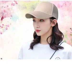 Vista detallada de una gorra de béisbol de malla beige transpirable en una modelo