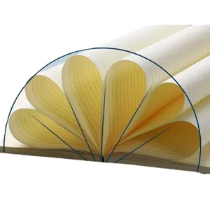 Close-up of beige lined notebook pages folded into a fan shape showing 180-degree flat opening