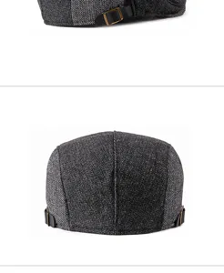 Detailed close-up of herringbone texture and back strap on a grey wool flat cap