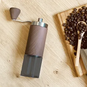 Detailed view of portable manual coffee grinder with wood grain finish on wooden table