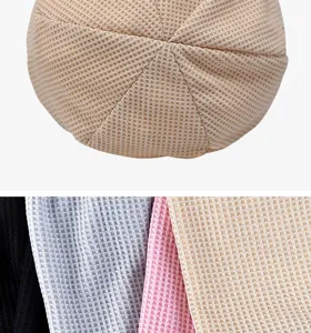 Macro view of waffle pattern beanie showing multiple color options and soft fabric texture