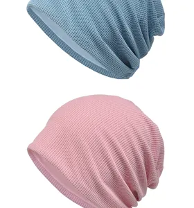 Close-up of blue and pink waffle knit beanies showing soft breathable texture