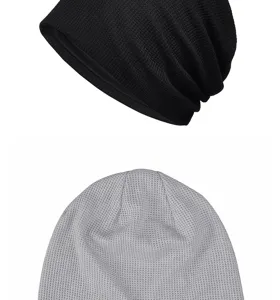 Close-up of black and grey waffle-knit slouchy beanies showing soft fabric texture