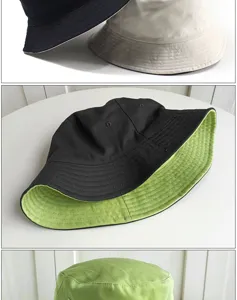 Detailed view of reversible cotton bucket hats in black, beige, and vibrant lime green colors