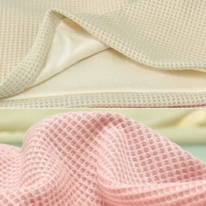 Close-up of soft waffle knit fabric in cream and pink for breathable slouchy beanies