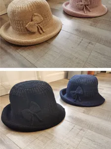 Detailed view of women's knitted bucket hats in beige pink black and navy colors