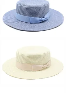 Dettagli ravvicinati di cappelli di paglia da donna blu e crema con fiocchi