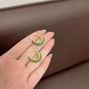 Detailed view of vintage green enamel U-shaped hoop earrings with a gold finish.
