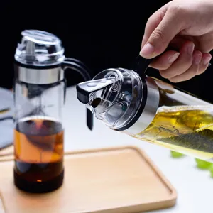 Nahaufnahme eines Glas-Ölspenders mit Schwerkraftdeckel beim Ausgießen in der Küche