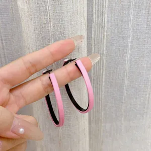Fashionable oversized pink geometric hoop earrings with textured leather finish