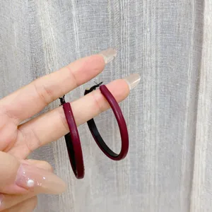 Large dark red minimalist geometric hoop earrings with a textured finish for women