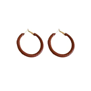 Detail view of retro Ankara red leather-wrapped hoop earrings with leopard texture