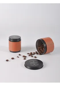 Recipiente portátil para granos de café con funda de cuero marrón y tapa metálica