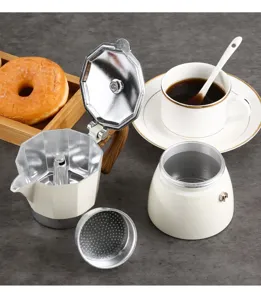 Detail view of a disassembled creamy white Moka pot with metal filter on grey background.